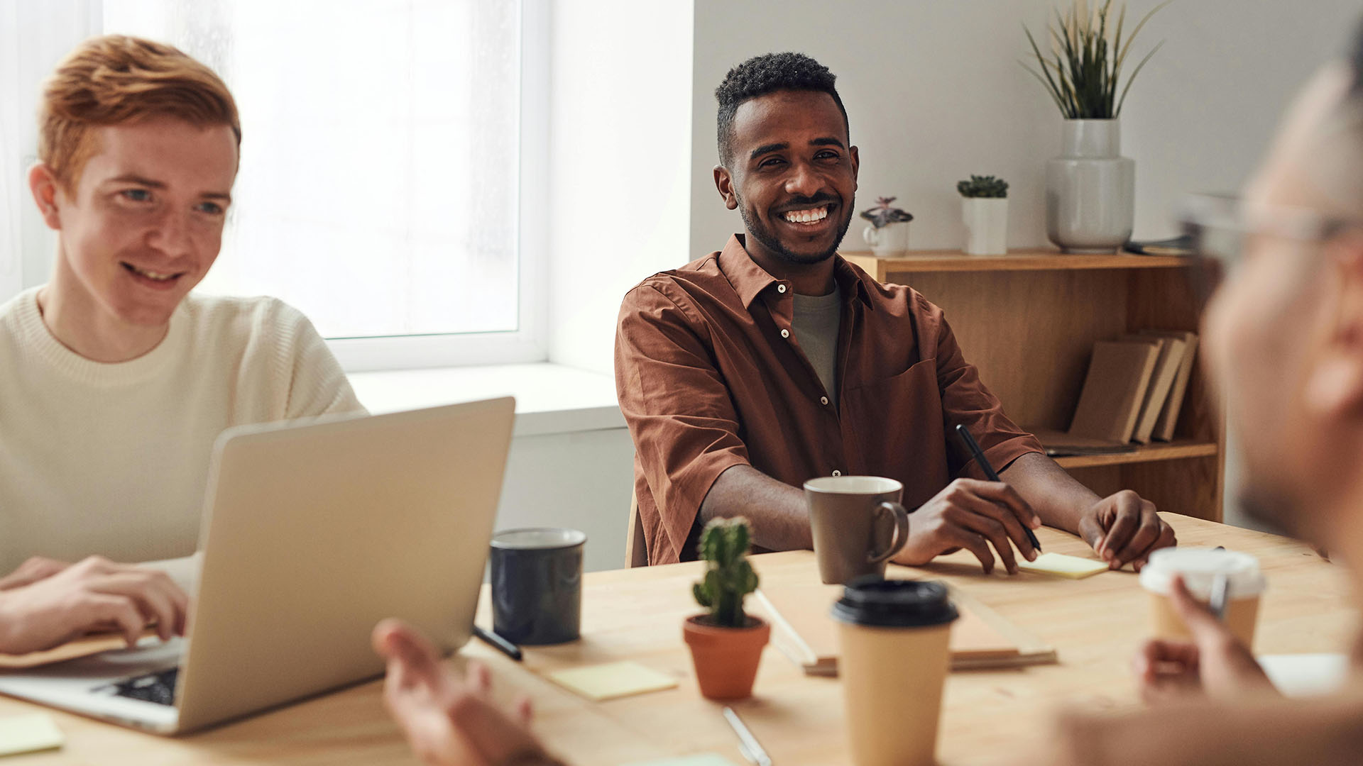 Small group of employees sitting at table smiling