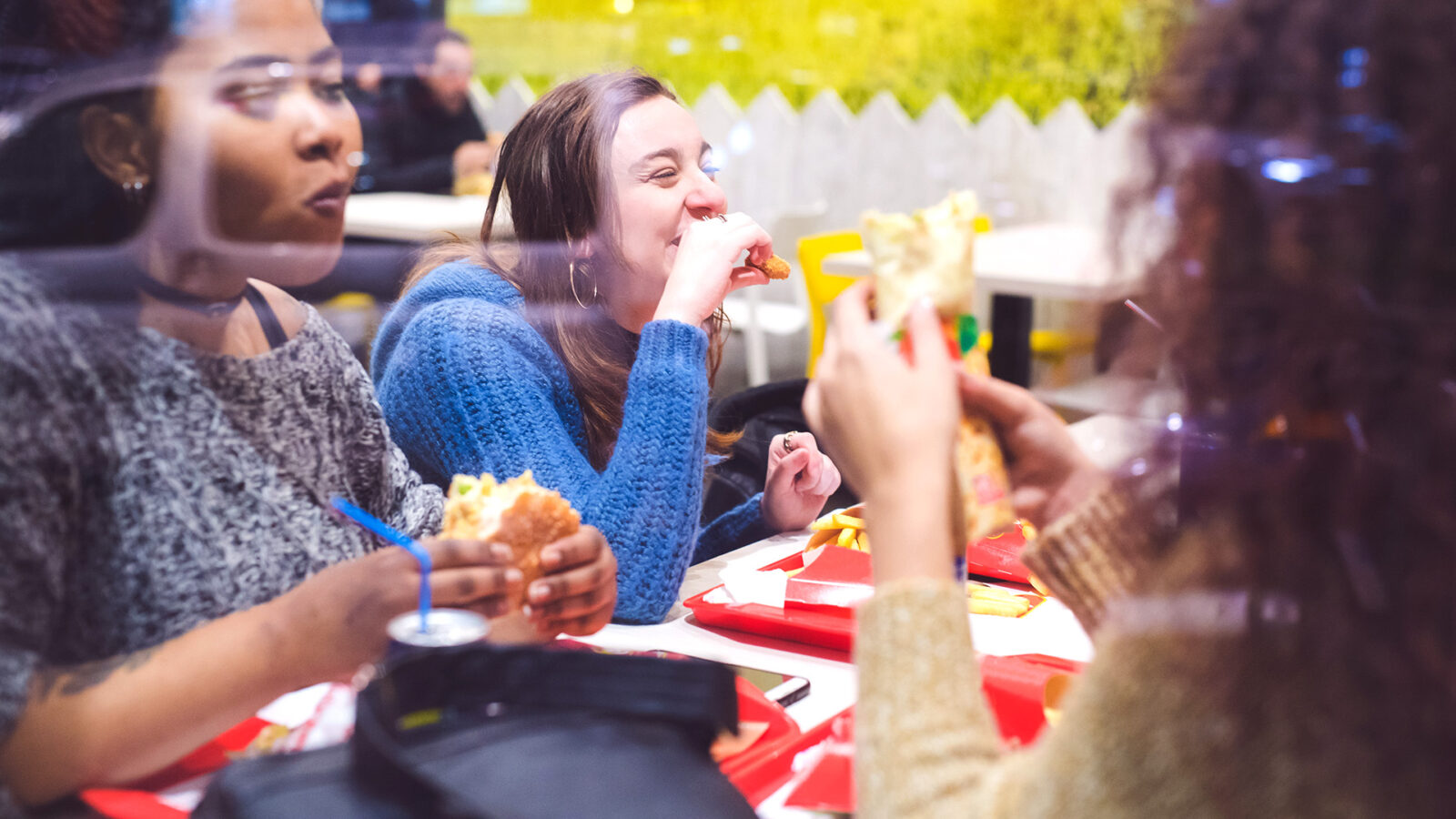 Group of girlfriends having a meal in a fast food restaurant.